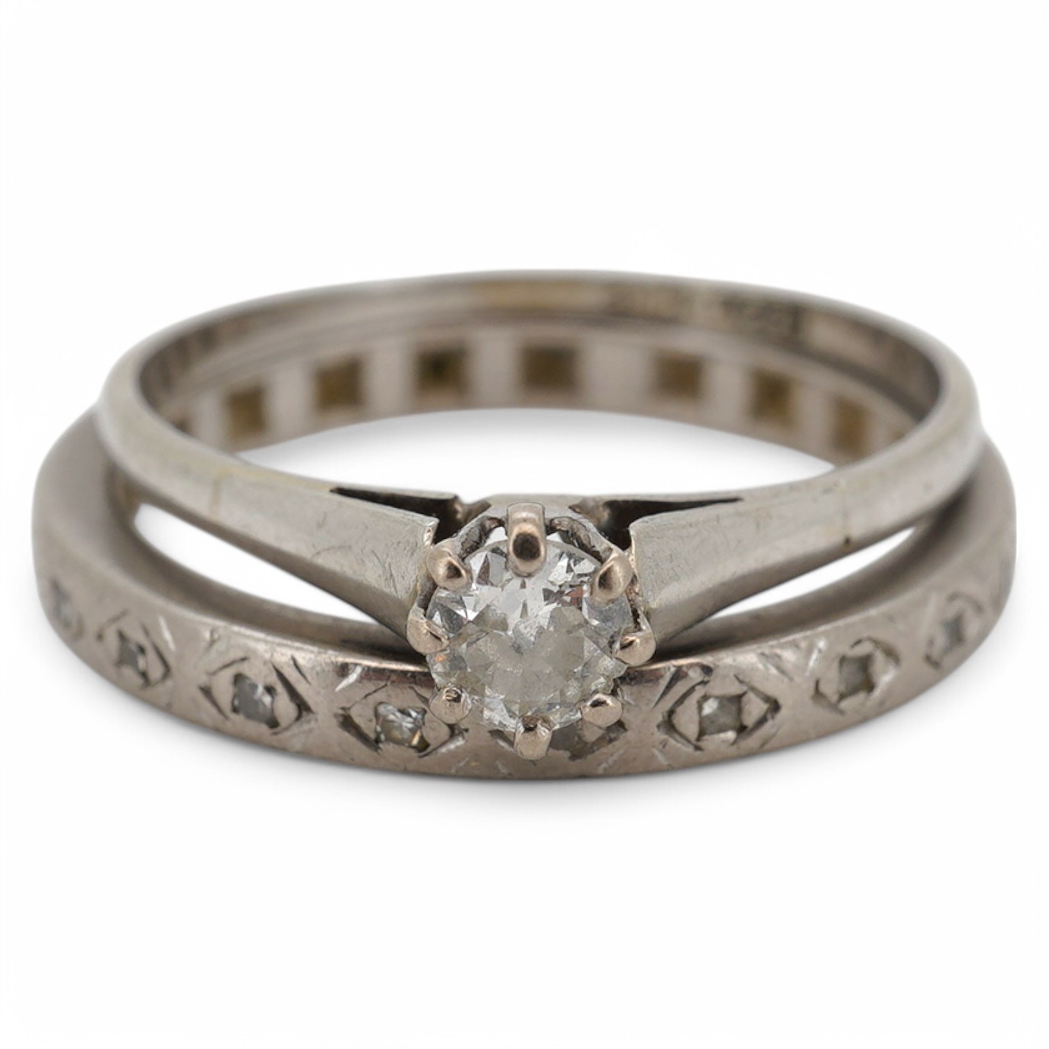 Two diamond rings, early 20th century, comprising: a solitaire ring set with an antique circular-cut diamond weighing approximately 0.15 carats, size O, stamped 18CT; and an eternity ring set with single-cut diamonds, si